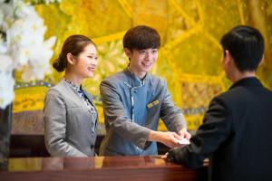 Un homme et une femme serrent la main à une table dans l'établissement Landison Plaza HSD Hotel Hangzhou, à Hangzhou 18 autres photos