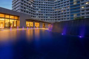 a large building with a pool in front of it at Landison Plaza HSD Hotel Hangzhou in Hangzhou