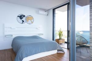 a bedroom with a bed and a large window at 3 bdr aprt, stunning seaview, rooftop pool - LCGR in Praia