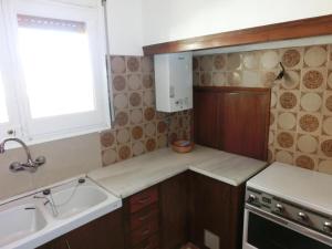 uma pequena cozinha com um lavatório e um fogão em Casa Llançà, 2 dormitorios, 5 personas - ES-228-17 em Llançà