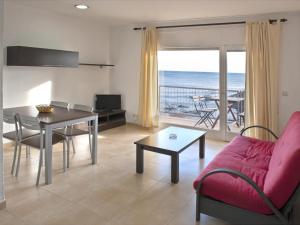 - un salon avec un canapé rouge et une table avec vue dans l'établissement Apartamento Llançà, 2 dormitorios, 6 personas - ES-228-36, à Llançà