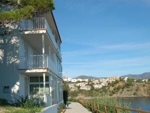- un bâtiment avec un balcon à côté d'une étendue d'eau dans l'établissement Apartamento Llançà, 2 dormitorios, 4 personas - ES-228-24, à Llançà