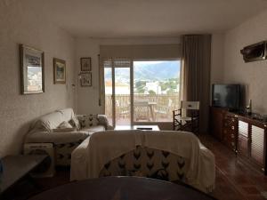 ein Wohnzimmer mit Sofa und Fernseher in der Unterkunft CABIONI - casa adosada con piscina comunitaria, cerca de la playa de Grifeu. - ES-228-39 in Llança