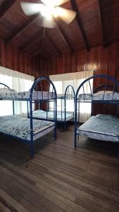 three bunk beds in a room with a ceiling at Hotel Las Palmas in Coco