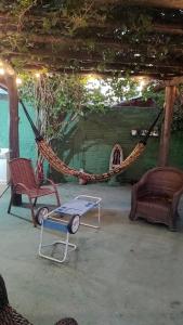 a hammock with two chairs and a table in a room at Graça de Casa in Florianópolis