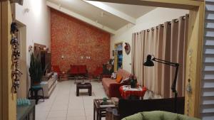 Graça de Casa في فلوريانوبوليس: غرفة معيشة مع أريكة حمراء وكراسي حمراء
