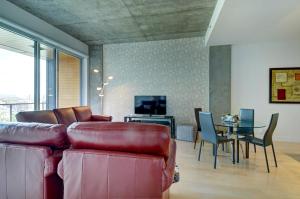 a living room with a leather couch and a table at Les Immeubles Charlevoix - Le 760102 in Quebec City