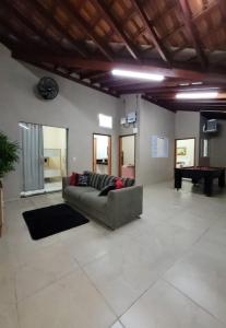 a living room with a couch and a piano at Recanto Fernanda in Olímpia