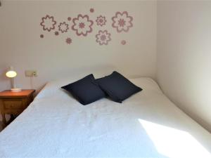 - une chambre avec un lit blanc et des oreillers bleus dans l'établissement Apartamento Llançà, 2 dormitorios, 5 personas - ES-228-63, à Llançà