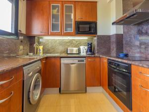 una piccola cucina con armadi in legno e lavastoviglie di LLEVANTINA 36 - Ático con gran terraza y vistas al mar en Llançà. - ES-228-66 a Llança