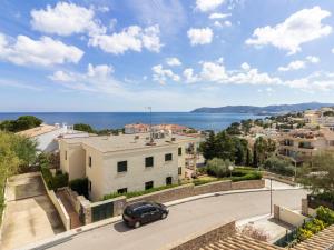 un'auto che guida lungo una strada accanto a un edificio di LLEVANTINA 36 - Ático con gran terraza y vistas al mar en Llançà. - ES-228-66 a Llança