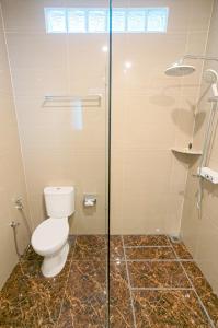 a bathroom with a toilet and a glass shower at Graha Socio Hotel Nusa Dua Bali in Nusa Dua