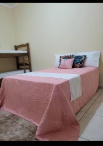 a bed with a pink blanket on top of it at Recanto Fernanda in Olímpia +17 photos