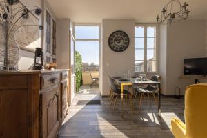cocina y comedor con mesa y reloj en la pared en LaConciergerieJonzac, Maison Côté Vintage avec jardin, en Jonzac