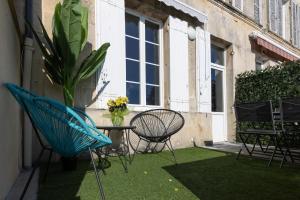 a patio with chairs and a table and a potted plant at Maison avec Jardin "Côté Vintage" in Jonzac