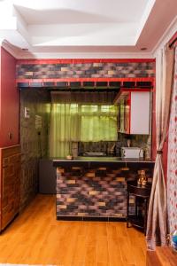 una cocina con una pared de ladrillo y una encimera en Green Villa Apartments en Kampala