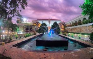 a fountain in front of a building at night at Centauria Lake Resort in Embilipitiya