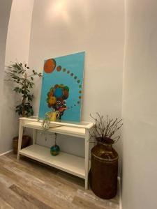 a white shelf with a painting and a mirror at Artistic luxury home downtown/train to NYC/AirPort in Newark
