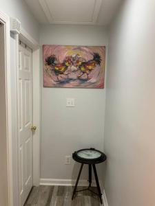 a room with a painting on the wall and a stool at Artistic luxury home downtown/train to NYC/AirPort in Newark