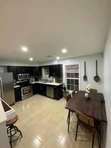 a large kitchen with a table and chairs in it at Artistic luxury home downtown/train to NYC/AirPort in Newark
