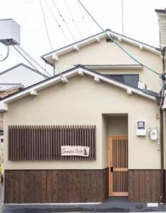 ein Haus mit einem Schild auf der Vorderseite in der Unterkunft Samurai Suite 1 , 15mins from Kyoto Eki , 5 mins to Arashiyama in Kyoto