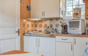 a kitchen with white cabinets and a sink and a microwave at Awesome Home In Onsala With 1 Bedrooms And Wifi in Onsala