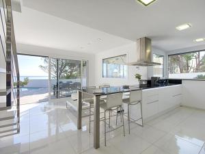 a kitchen with a table and some chairs and windows at MYFENOLLEDA B - Preciosa casa en Grifeu con piscina compartida y parking - ES-228-126 in Llança