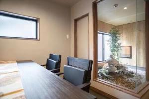 een kamer met een tafel en stoelen en een grote spiegel bij Samurai Suite 1 , 15mins from Kyoto Eki , 5 mins to Arashiyama in Kyoto