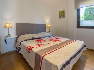ein Schlafzimmer mit einem Bett mit roten Blumen darauf in der Unterkunft Apartamento de lujo frente al mar en Playa de la Tonyines, 3 habitaciones, terraza, garaje y más - ES-228-127 in Llança