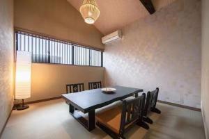 ein Esszimmer mit einem schwarzen Tisch und Stühlen in der Unterkunft Samurai Suite 1 , 15mins from Kyoto Eki , 5 mins to Arashiyama in Kyoto