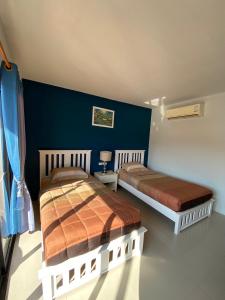 2 camas en un dormitorio con una pared azul en Phi Phi Top View Resort en Islas Phi Phi