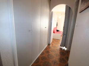korytarz z pokojem z czerwonym łóżkiem w pokoju w obiekcie Grand studio climatisé pour 4 personnes avec parking, à 350m de la mer au Grau-du-Roi - FR-1-307-222 w mieście Le Grau-du-Roi