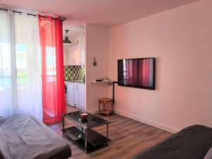 ein Wohnzimmer mit einem Sofa und einem TV an der Wand in der Unterkunft Appartement Cap d'Agde, 2 pièces, 6 personnes - FR-1-249-387 in Cap d'Agde
