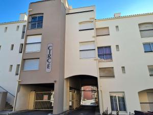 ein weißes Apartmenthaus mit einem Tunnel, der hinein führt in der Unterkunft Appartement Cap d'Agde, 2 pièces, 6 personnes - FR-1-249-387 in Cap d'Agde