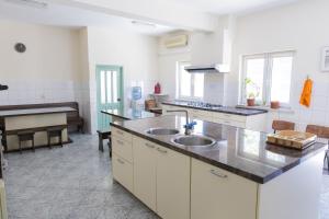 a large white kitchen with a sink and a piano at Hostel Holland Bacau in Bacău