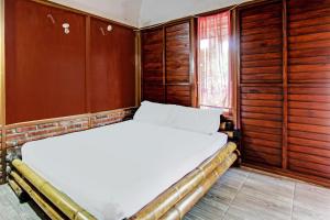 龍目島的住宿－OYO 92354 Samalas Syariah Homestay，木镶板客房内的一张床位