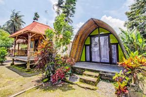 a small green house with a window and a porch at OYO 92354 Samalas Syariah Homestay in Labuan Lombok