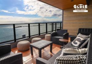 a balcony with couches and a view of the water at GLOCE ル グランブリュリゾート長沢 l テラスでゆったりオーシャンビュージャグジー 1棟貸し切り 小型犬可 無料駐車場付 in Kōembō