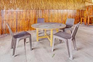 a wooden table and two chairs and a wooden wall at OYO 92354 Samalas Syariah Homestay in Labuan Lombok