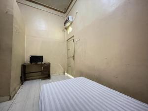 sypialnia z łóżkiem, komodą i drzwiami w obiekcie SPOT ON 92362 Pondokan Tali Super w mieście Parepare