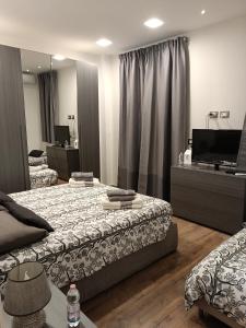 カターニアにあるYoreのベッド2台と薄型テレビ付きのベッドルーム