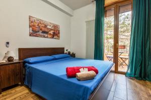 een slaapkamer met een blauw bed en een rood kussen bij B&B Selvarossa in Bologna
