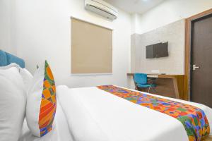 a hotel room with a bed and a television at FabHotel Ramya in Indore