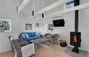 uma sala de estar com um sofá azul e uma lareira em 3 Bedroom Beautiful Home In Nrre Nebel em Nørre Nebel