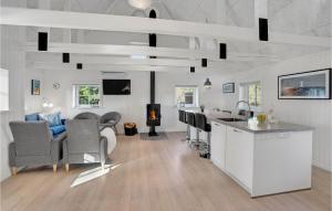 Nørre NebelにあるThree-Bedroom Holiday Home In Norre Nebelのリビングルーム(キッチン付)、リビングルーム(暖炉付)