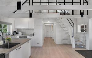 uma cozinha com armários brancos e uma escada em espiral em 3 Bedroom Beautiful Home In Nrre Nebel em Nørre Nebel