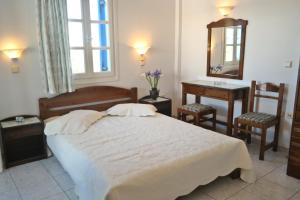1 dormitorio con cama, mesa y espejo en Mina's Studios in Naxos Island, en Agios Prokopios