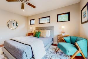 a bedroom with a bed and a blue chair at Westbrook Wonder in Austin