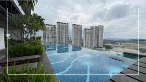 een zwembad bovenop een gebouw met hoge gebouwen bij Sri Murni Homestay Aurora Place Bukit Jalil in Kuala Lumpur