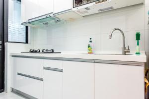 a kitchen with white cabinets and a sink at 綠舍睡到民宿 in Taitung City +33 photos